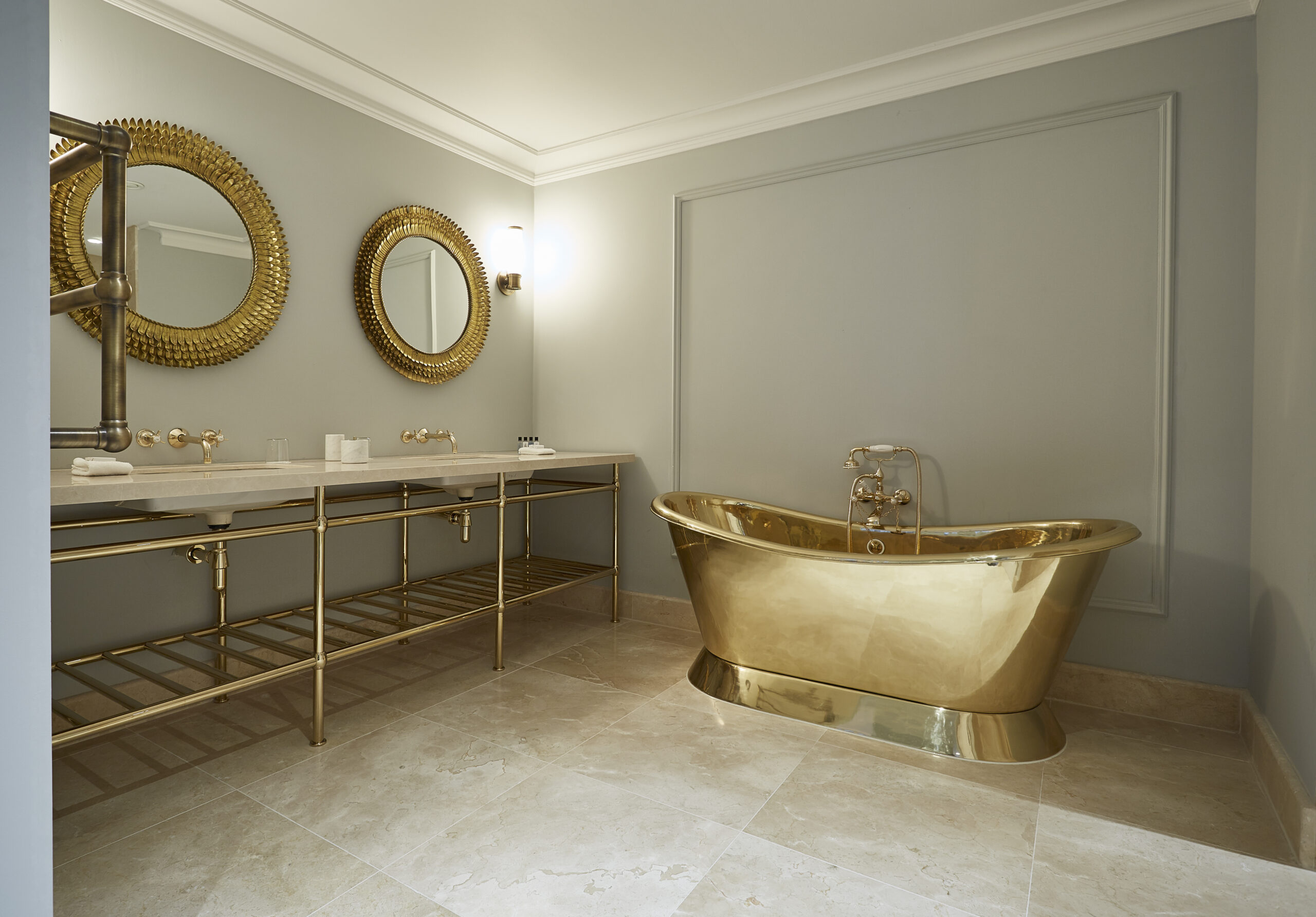 Lympstone Manor - interior of luxury bathroom with stone - marble floor and gold bath